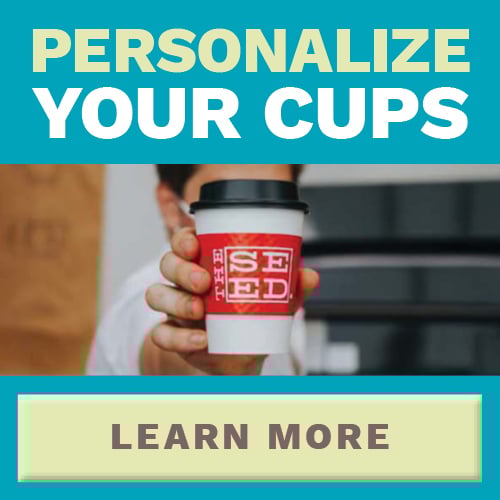 Man holding a white cup with black lid and a personalized sleeve